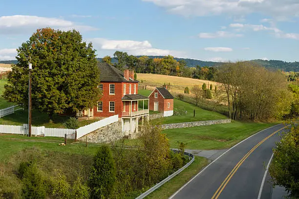 "Farmhouse along a rural road through the countryside, the Sherrick house on the Antietam battlefield in Maryland, USA."