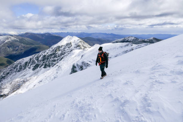 istock Man In snowy mountains going down a snowy hill with crampons 1713551288
