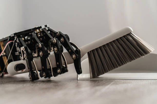 istock Robotic hand skillfully using a dustpan and brush to sweep the floor 1713555787