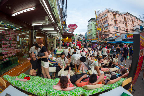 Bangkok, Thailand - March 22, 2014: Thai masseur doing massage outdoors at the famous backpackers destination Khao San Road at night