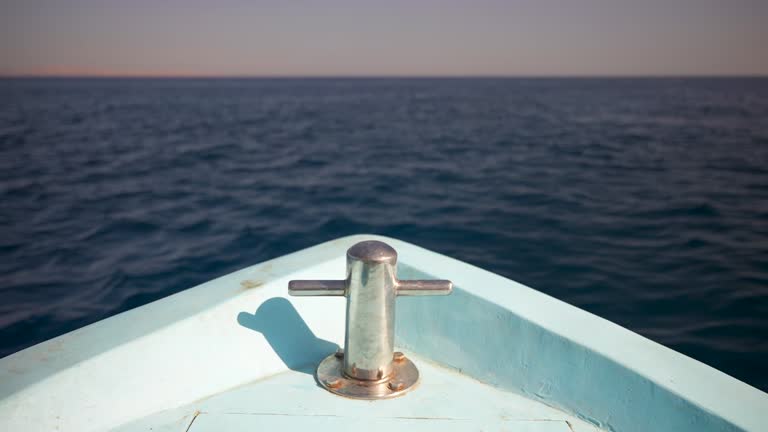 Close up bow of a floating in the sea boat with empty bitts for mooring