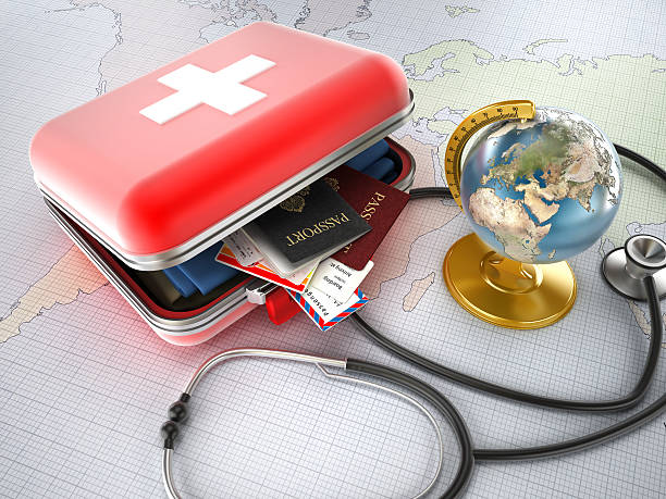 Medical tourism First-aid kit designed as a suitcase with passports, plane tickets and clothes inside, stethoscope and globe standing on world map. Medical tourism concept. earth first aid stock pictures, royalty-free photos & images