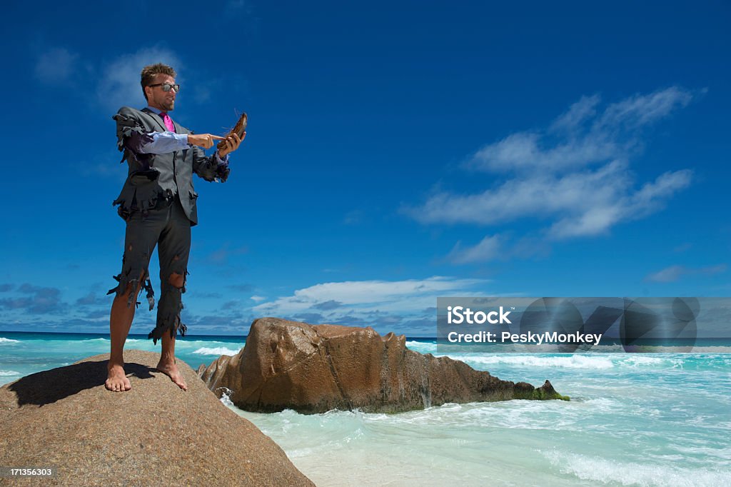 Castaway Geschäftsmann verwendet Kokosnuss Smartphone am Strand - Lizenzfrei Einsame Insel Stock-Foto