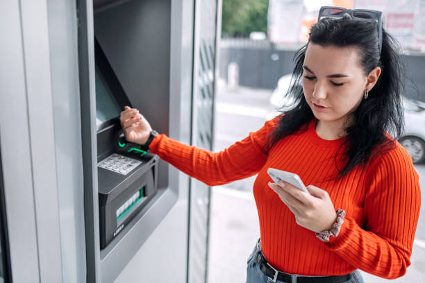 istock Young woman in front of ATM using smart watch 1713565235