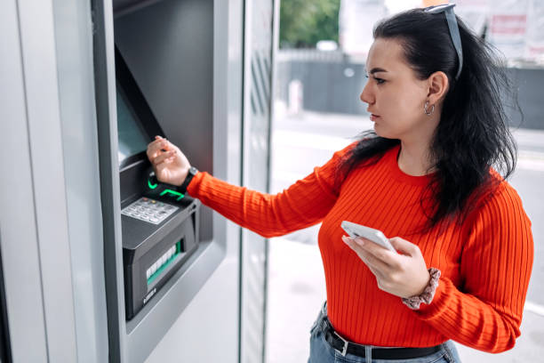 istock Young woman in front of ATM using smart watch 1713565238