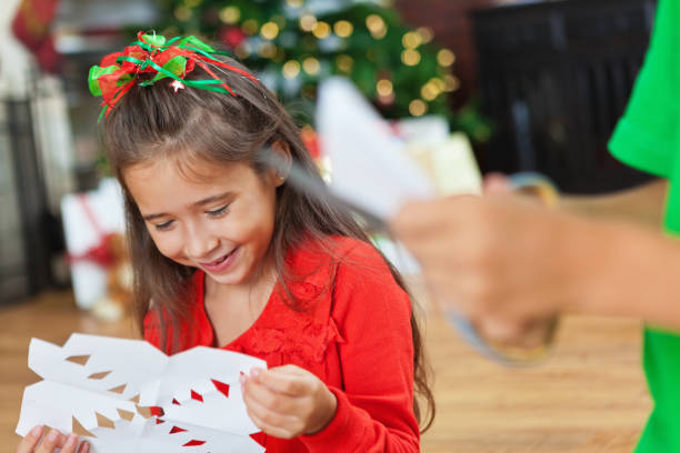 istock Siblings in red and green make Christmas snowflakes. 171356612