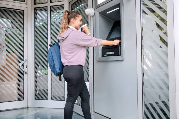 istock Young woman in front of ATM 1713566321