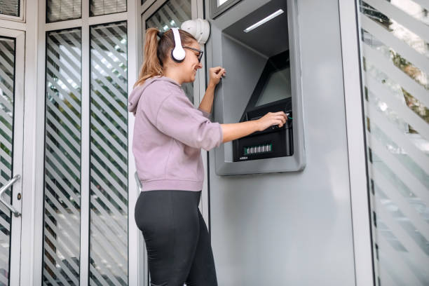 istock Young woman in front of ATM 1713566344
