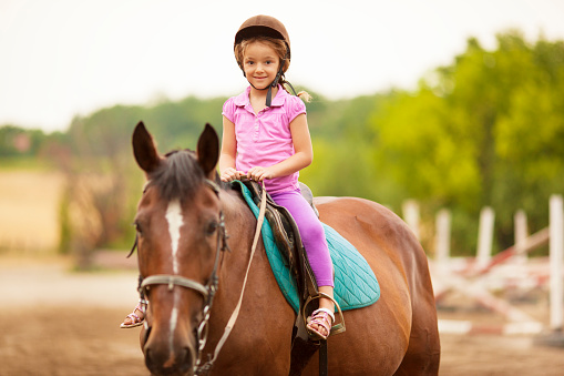 Child Riding Horse Outdoors.