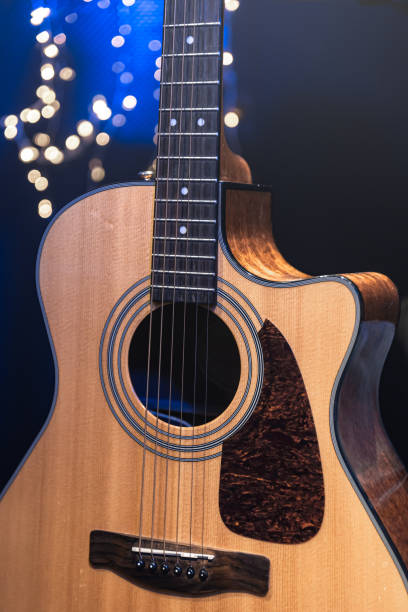 istock Close-up, acoustic guitar on a dark background with bokeh lights. 1713570187