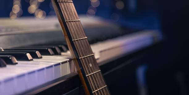 istock Guitar and piano keys close-up on a blurred background with bokeh. 1713570194