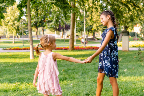 istock Two happy girls walking through the park 1713575347