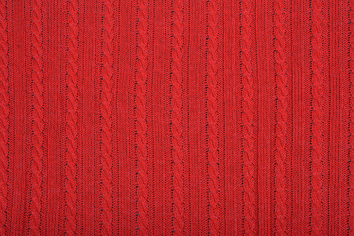 Knitted background. Knitted red texture. A knitting pattern of wool. Knitting. Background.