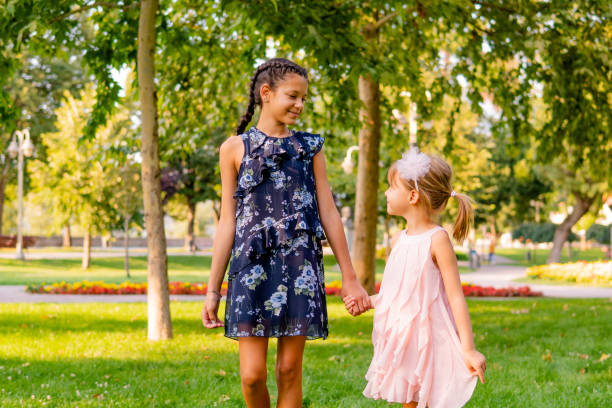 istock Two happy girls walking through the park 1713578100