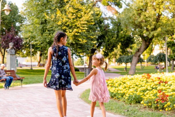 istock Two happy girls walking through the park 1713579792
