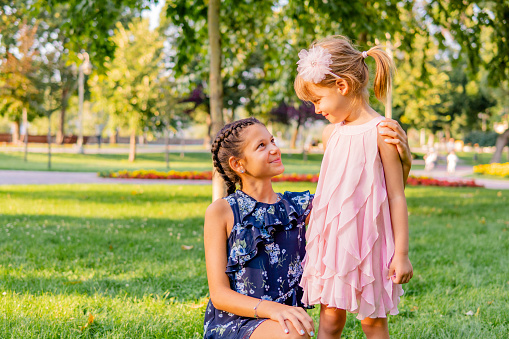 Cute little girl enjoy with her older sister in the park.