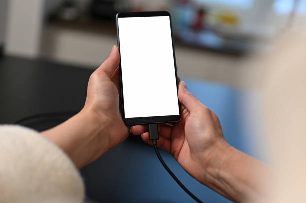 istock female user holding smartphone in hands, mobile phone white blank screen mockup, using mobile apps at home. 1713582811