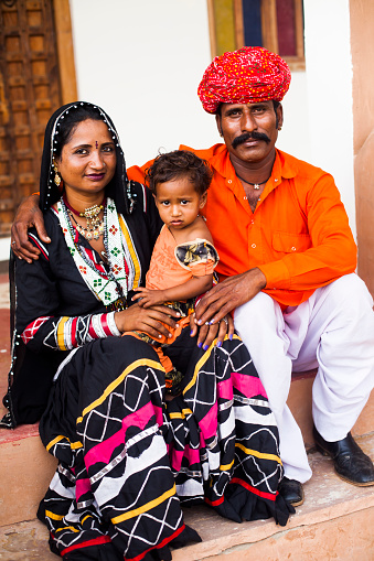Closeup shot of a cute Indian family with child, smiling at camerahttp://dl.dropbox.com/u/26686368/IS-BUTTON_INDIA.jpg
