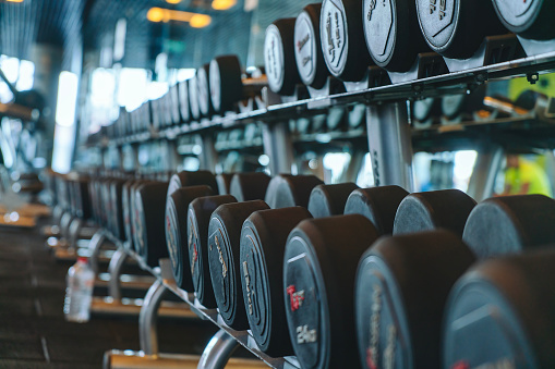 Dumbbells in a row, weight training exercising equipment in gym