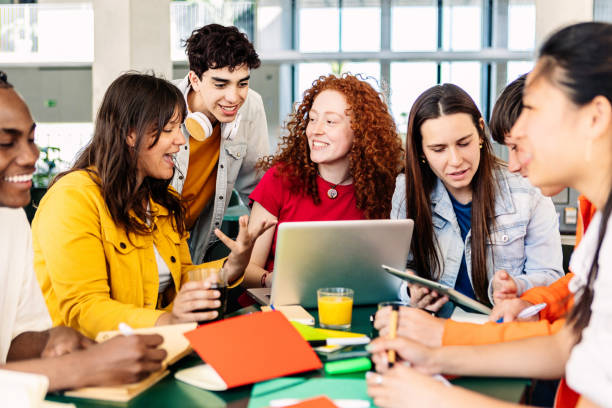 Group of college people studying together on cafeteria table at campus stock photo