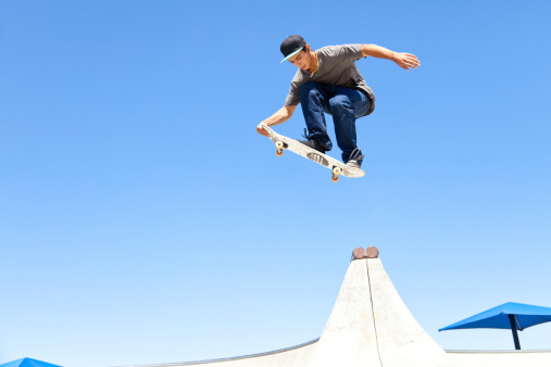 XXXL. Young man doing an air walk skateboard trick.