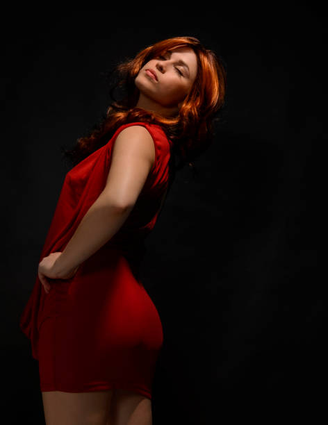 Lonely redhead woman sitting in a mud surrounded by water.