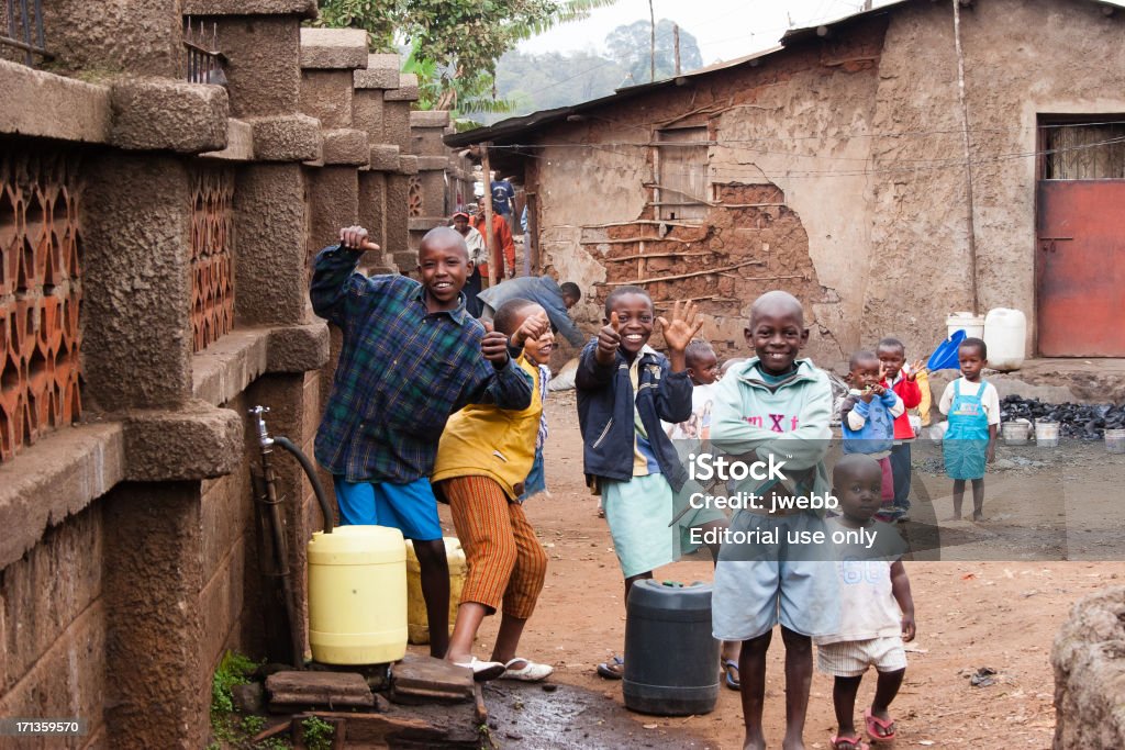 Boys Collecting Water in African Slum "Kibera Slum, Nairobi, Kenya. March 18, 2006:  - A group of boys pose for the camera as they collect clean drinking water from one of the few water supply pipes. Kibera is the largest slum in Africa and the second largest slum in the world" UNICEF Stock Photo
