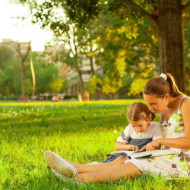 istock Mother with daughter  reading book outdoor 171361192
