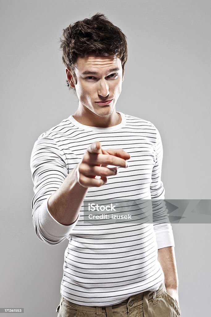 You! Portrait of confident young man pointing at the camera. Studio shot, grey background. Pointing Stock Photo