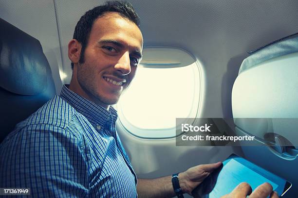 Foto de Homem De Negócios Usando Um Tablet Digital No Avião e mais fotos de stock de 25-30 Anos