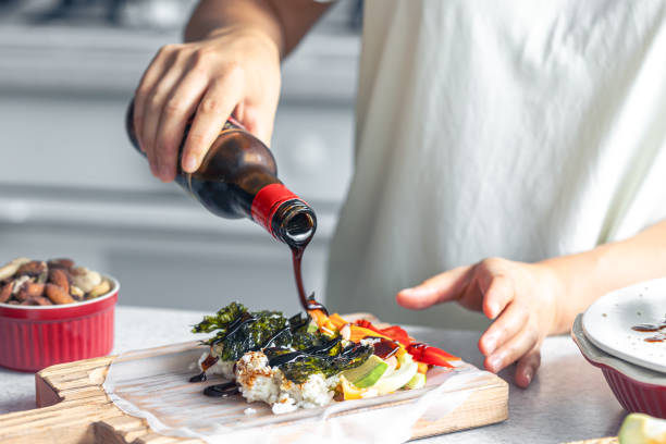 istock Woman preparing spring rolls in rice paper on kitchen table. 1713619802