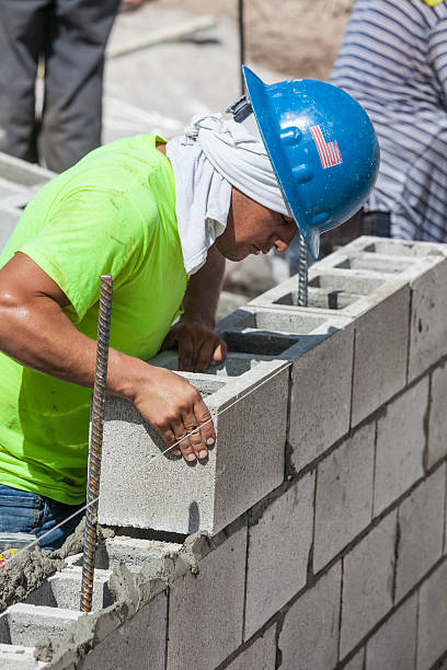 istock Construction Worker Puts Cinder Block in PLace on New Wall 171362147