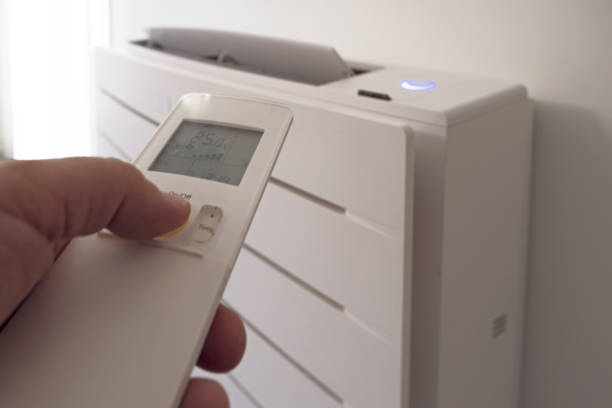 istock Human hand uses remote control, presses buttons, sets selects temperature of air cooling in home. 1713621555