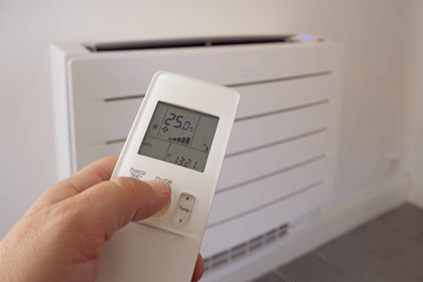 istock Human hand uses remote control, presses buttons, sets selects temperature of air cooling in home. 1713622082