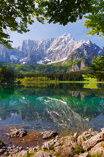 Picturesque mountain scenery and hiking place. Beautiful superior Fusine lake and Mangart mountain in background, Julian Alps, Tarvisio, Udine region, Friuli Venezia Giulia, Italy, Europe