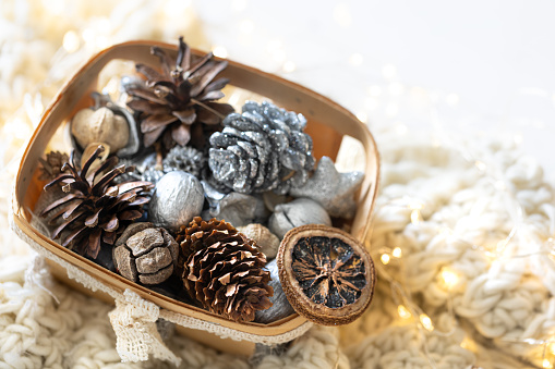 Cozy winter still life, Christmas decorations in box on cozy blanket, atmospheric scandinavian mood, close up.