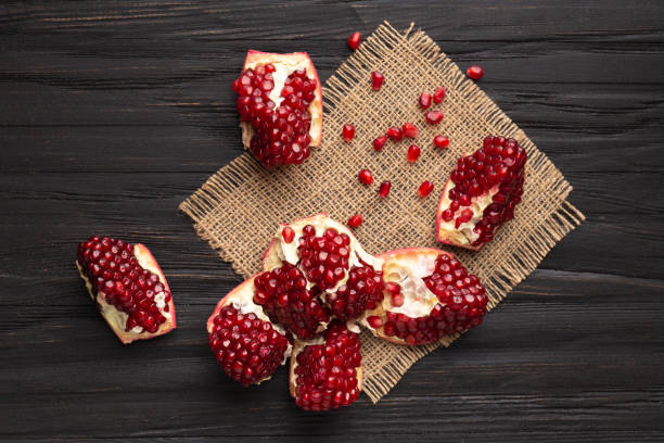 istock Broken into pieces pomegranate on a wooden background 1713634955