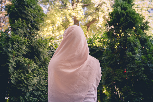 Autumn. Lonely muslim woman in a headscarf  walking in a park, garden. Vintage Toned