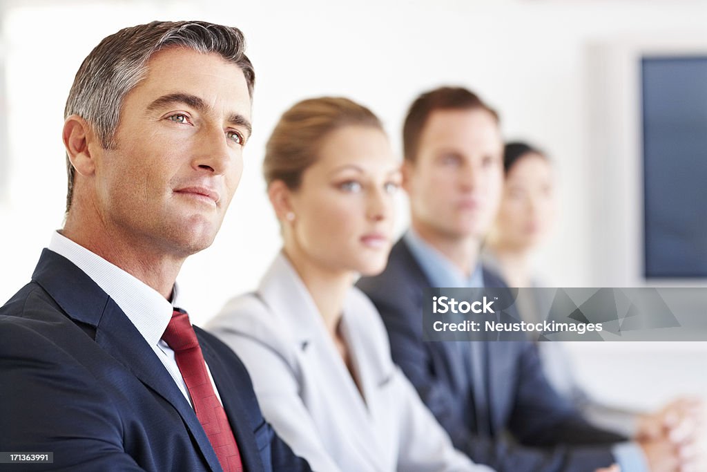 Attentive Business Executive Mature business executive in conference meeting with associates. Horizontal shot. CEO Stock Photo