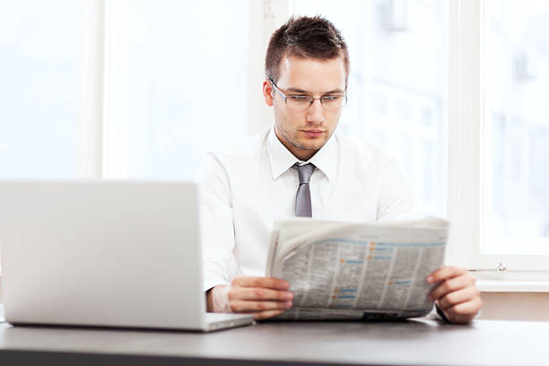 istock Handsome businessman reading newspaper 171364488