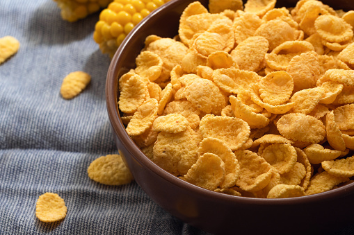 Corn flakes in a bowl on the table close-up, quick breakfast.