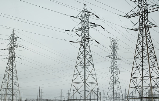 Low angle view of a series of transmission towers on southwestern Ontario. Overcast skies on a summer afternoon.