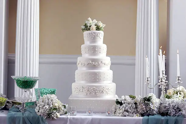 Ornate elegant fancy large wedding cake as the centerpiece at a beautiful wedding reception.