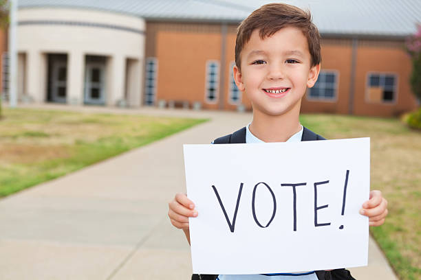 istock Happy young student at school holding a Vote Sign 171364771