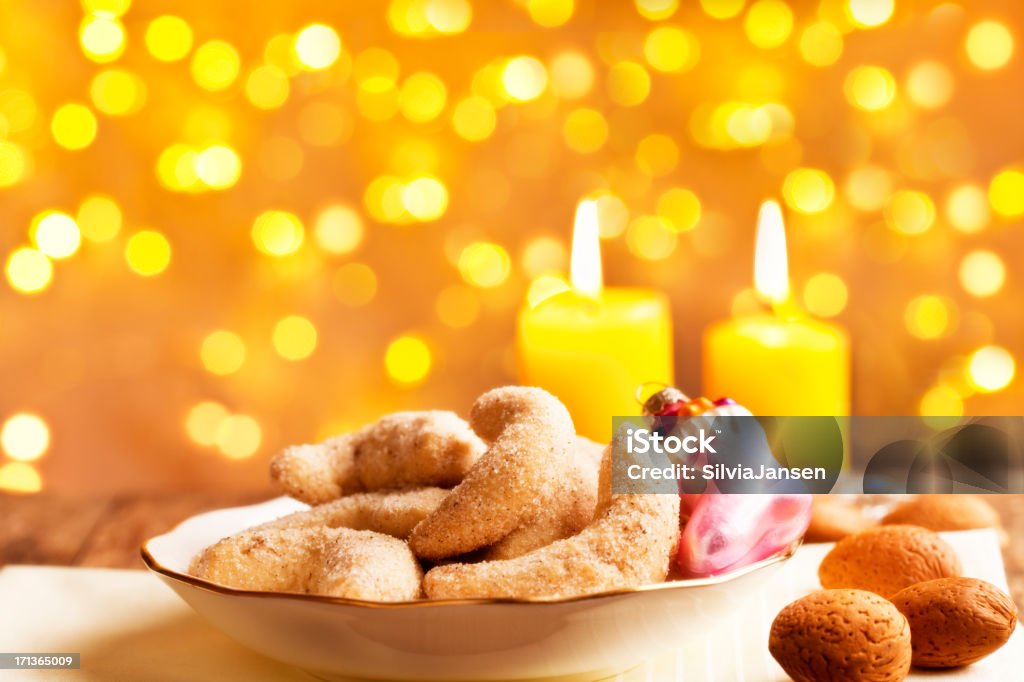 traditional christmas cookies Vanillekipferl and lights homemade christmas cookies, called Vanillekipferl,, almonds and christmas decoration, in front of candle and golden lights Almond Stock Photo