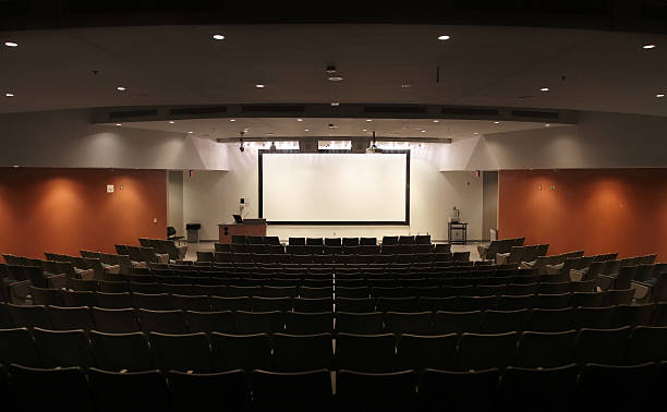 Very Large Modern University Lecture Hall "A modern university lecture hall, also used for conferences, presentations, and film screenings." projector screen classroom stock pictures, royalty-free photos & images