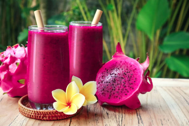 Dragon fruit smoothie in glass Dragon fruit smoothie in glass on table in tropical cafe outdoor dragon fruit flower stock pictures, royalty-free photos & images