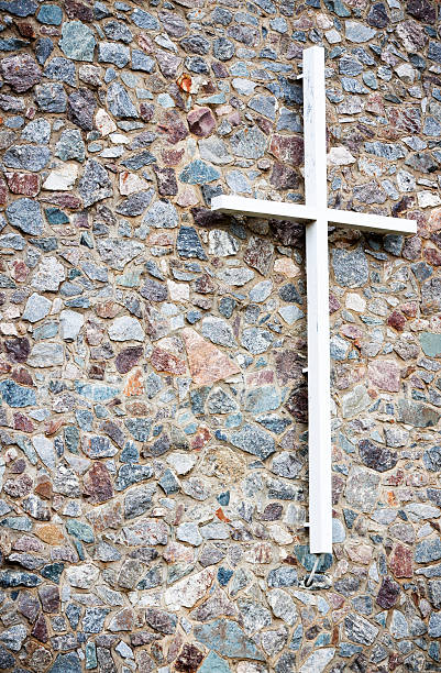 istock White wooden cross on stone wall, copy space 171365742