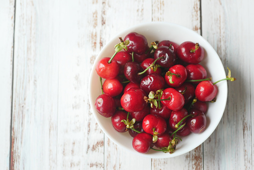 Bowl of cherries on a wooden background ,