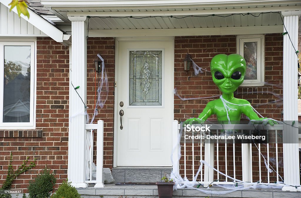 Alien On The Front Porch A green alien on the front porch of a house for Halloween. Alien Stock Photo